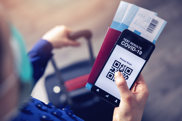 person in airport using mobile app in phone to show covid-19 test results for travel covid restrictions
